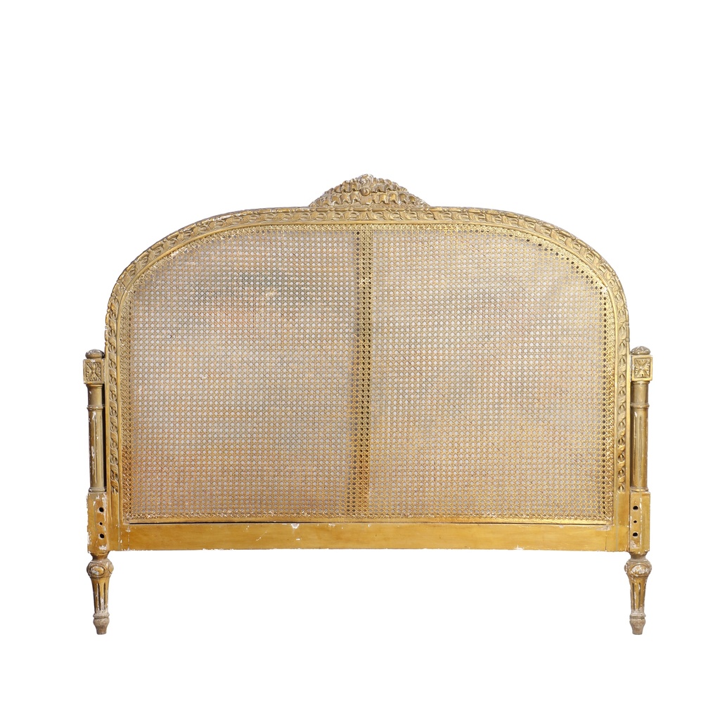 Upholstered bed with gilded details.